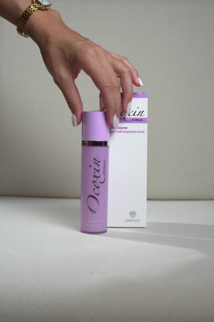 Ocoxín Cream 50 ml — mão segurando o frasco e a embalagem